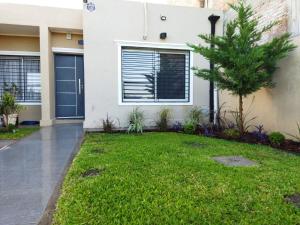 a house with a lawn in front of it at Terra in Capitán Bermúdez +3 photos