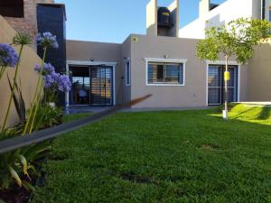 a fence in front of a yard with a house at Terra in Capitán Bermúdez