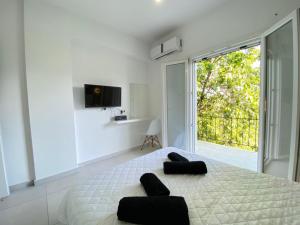 a white bedroom with a large bed and a window at Alexander apartment 2 in Spartia