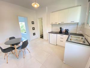 a kitchen with white cabinets and a table and chairs at Alexander apartment 2 in Spartia