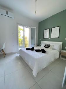 a bedroom with a large white bed and a green wall at Alexander apartment 2 in Spartia