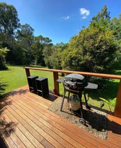 a grill sitting on a wooden deck with a field at Kosmo’s Studio: City Style in a Retreat Setting! in Boyland