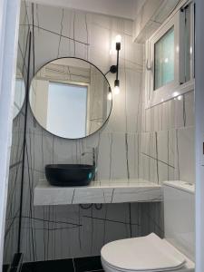 a bathroom with a sink and a mirror and a toilet at Alexander apartment 2 in Spartia