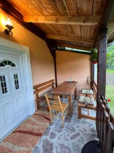 une terrasse couverte avec une table en bois et un banc dans l'établissement Holiday House Tara, à Kolašin