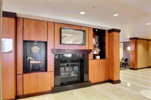 a living room with a fireplace and a chair at Fairfield Inn & Suites by Marriott Milwaukee Airport in Oak Creek