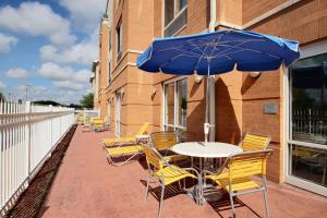 a table and chairs with an umbrella on a patio at Fairfield Inn & Suites by Marriott Milwaukee Airport in Oak Creek