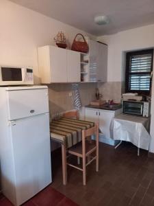 a kitchen with a refrigerator and a table in it at Apartments IRINA in Donji Stoliv