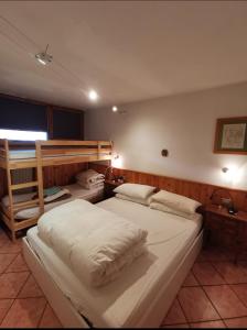 a bedroom with two beds and a bunk bed at Val di Sole Holidays in Folgarida