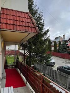 una alfombra roja en el lateral de una casa en Constantinescu A en Buşteni