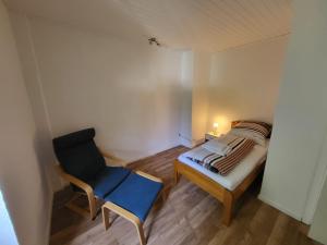ein kleines Schlafzimmer mit einem Bett und einem Stuhl in der Unterkunft Privatzimmer an der Uniklinik Mainz in Mainz