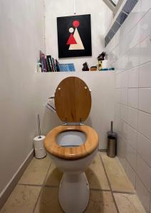 a toilet with a wooden seat in a bathroom at Duplex proche mer, avec swimspa terrasse, jardin et barbecue in Lapalme