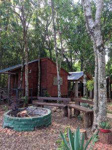 a cabin in the woods with a picnic table and a fire pit at Cabañas El Portal in Jardín América