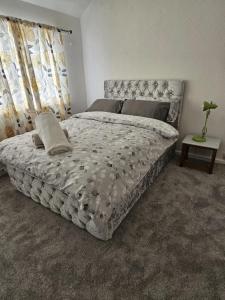a bedroom with a large bed with a white comforter at Mo's home in Tilbury