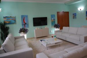 a living room with two couches and a tv at Hotel Citti in Arzachena