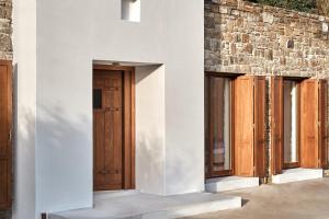 a row of wooden doors on a building at Christina's Panormos Villa in Mykonos +46 photos