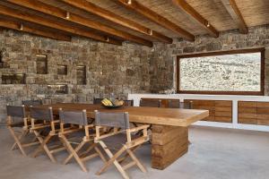 a dining room with a wooden table and chairs at Christina's Panormos Villa in Mykonos