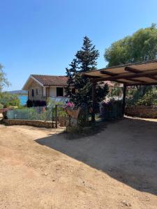 a house with a fence and a gate and a woodenilion at Baia Dorata beach apartments in Porto Istana