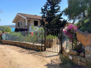 a gate in front of a house with flowers at Baia Dorata beach apartments in Porto Istana