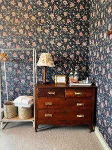 a bedroom with a dresser with a lamp on it at Atlantic Inn in New Shoreham