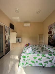 una camera da letto con un letto con un piumone verde di Vila dos Gnomos Paraíso Místico Pé na Areia a Ilhéus