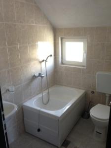 a bathroom with a tub and a sink and a toilet at Apartment Ana Marija in Mavrovo