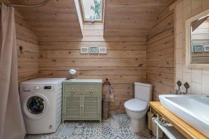 een badkamer met een wasmachine en een toilet bij Vila Shakti in Rudžionys