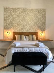 - une chambre avec un grand lit et un grand mur dans l'établissement Apartamentos Makao Puerta del Olivillo, à Jerez de la Frontera