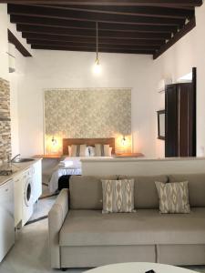 a living room with a couch and a bed at Apartamentos Makao Puerta del Olivillo in Jerez de la Frontera