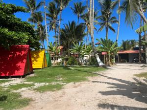 plaży z palmami i kolorowymi budynkami w obiekcie Camping Gnomo Místico w mieście Olivença