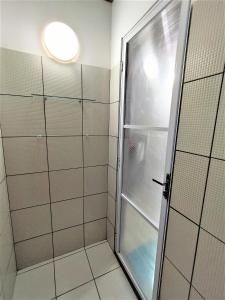 a shower with a glass door in a bathroom at Bangalô Panorâmica in Conde