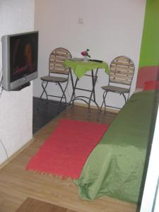 una camera con due sedie, un tavolo e una TV di Guesthouse Panorama a Mostar