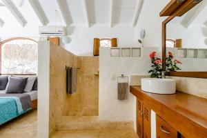 a bathroom with a sink and a bed in a room at Casa Picaflor in Las Terrenas