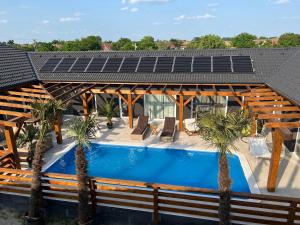 a house with a swimming pool with a solar roof at Dunavölgyi Vendégház Akasztó in Akasztó