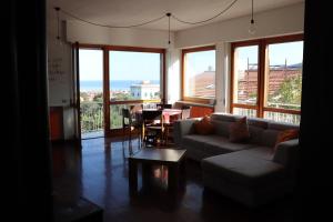 - un salon avec un canapé, une table et des fenêtres dans l'établissement Casa Basso, à Loano