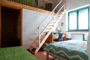 1 dormitorio con una escalera junto a una cama y un escritorio en Villa Etna, en Nicolosi