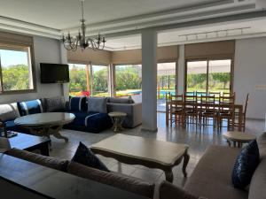 a living room with a couch and a table and chairs at Maison de Campagne in Dar SaÃ¯d Ben Hajj