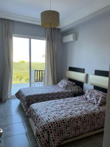 - 2 lits dans une chambre d'hôtel avec fenêtre dans l'établissement Maison de Campagne, à Dar SaÃ¯d Ben Hajj