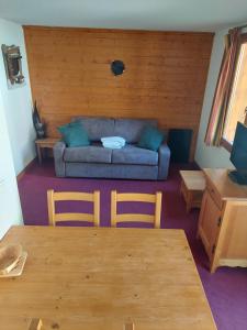 a living room with a couch and a table and chairs at Résidence les chalets du Galibier Piscine Sauna Hammam WIFI in Valloire