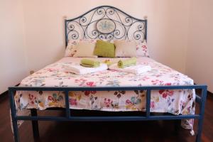 a bed with a floral bedspread and pillows on it at Casa Basso in Loano