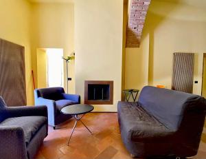 a living room with a couch and chairs and a fireplace at Perugia Abbraccio Etrusco in Perugia