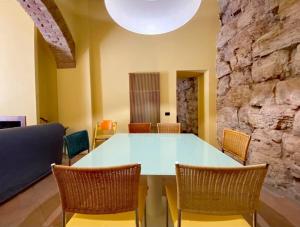 een tafel en stoelen in een kamer met een stenen muur bij Perugia Abbraccio Etrusco in Perugia