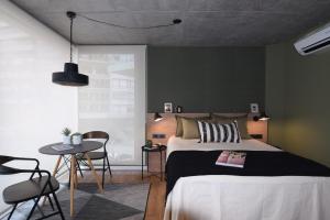 1 dormitorio con 1 cama, mesa y sillas en Diseño con vistas al Parque y Mar Punta Carretas, en Montevideo