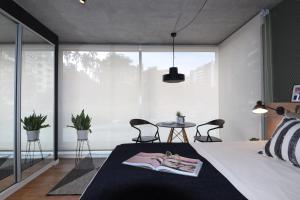 una camera con letto, tavolo e sedie di Diseño con vistas al Parque y Mar Punta Carretas a Montevideo