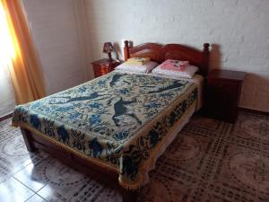 a bedroom with a bed with a quilt on it at CASA PARA ALQUILER LA LILI in Uspallata