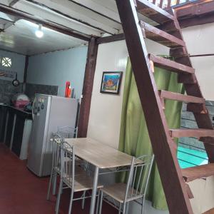cocina con mesa, sillas y nevera en Klay's tiny home en San Isidro