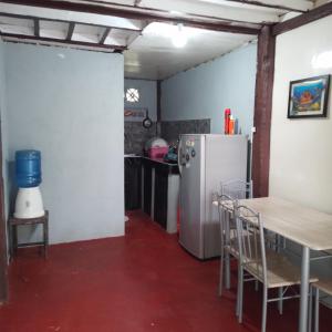 uma cozinha com um frigorífico, uma mesa e cadeiras em Klay's tiny home em San Isidro