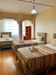 a bedroom with two beds and two windows at Ulubat Castle Hotel in Istanbul