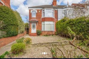 a brick house with a garden in front of it at cleethorpes seaside garden apartment in Cleethorpes