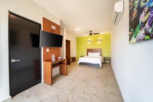 a bedroom with a bed and a flat screen tv at Villas Coral Huatulco in Santa Cruz Huatulco