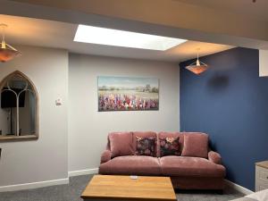 a living room with a brown couch and a painting at Y Teifi - room only in Llandysul